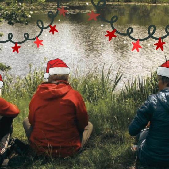 Billede af mennesker ved en sø - redigeret med nissehuer på og en juleguirlande