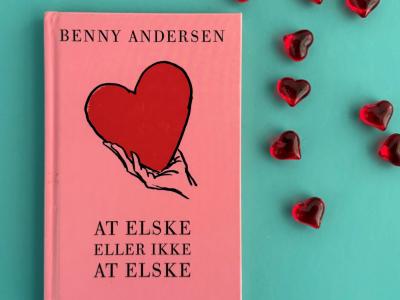 Foto af bogen "At elske eller ikke at elske" af Benny Andersen med hjerter ved siden af